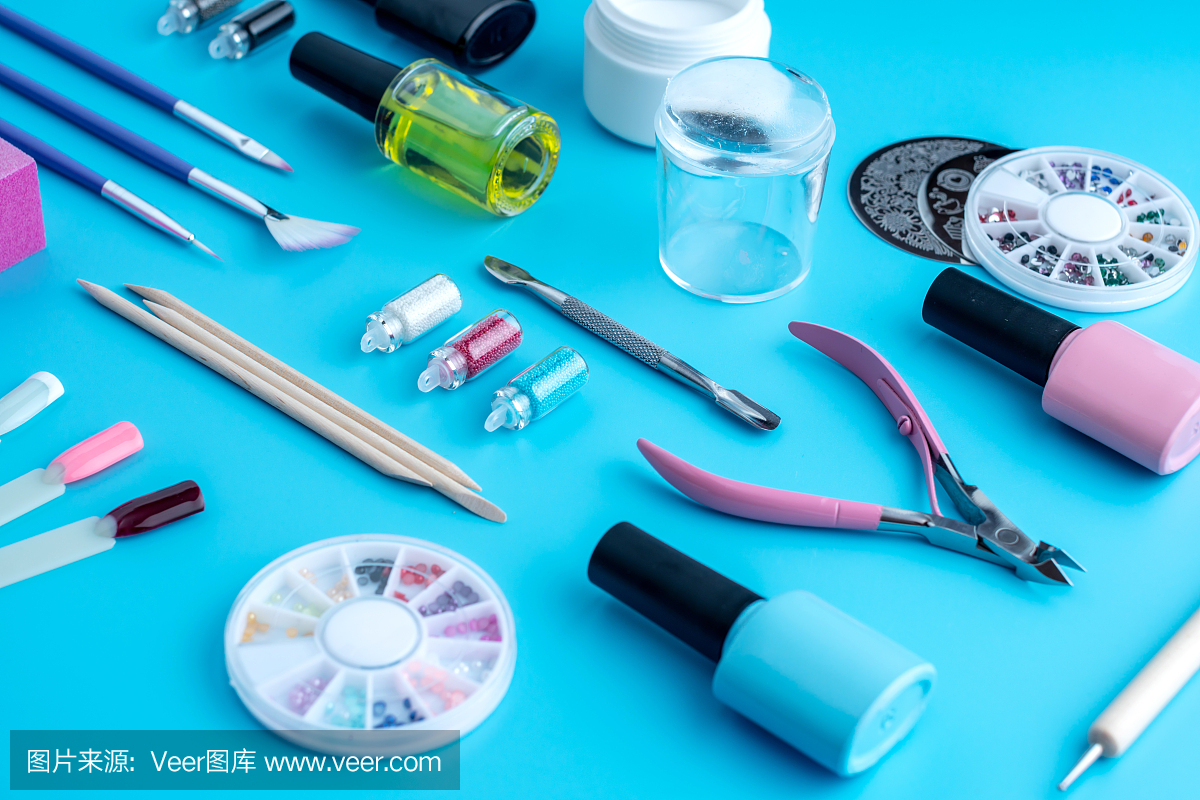 一套化妆品工具的专业美甲和指甲护理在蓝色的背景。俯视图